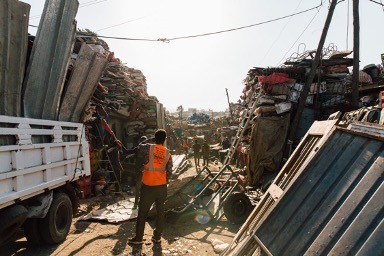 a workman stands between piles of ferrous and non-ferrous scrap metal